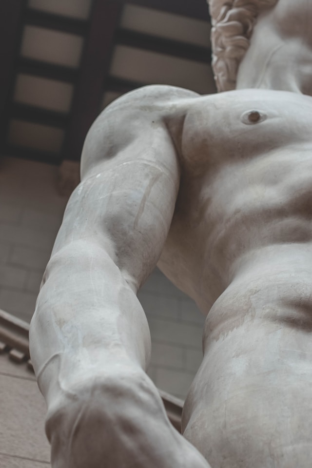 Up close, Michelangelo's David sculpture reveals intricate details, from muscular sinews to intense gaze, exuding timeless vitality and grace.